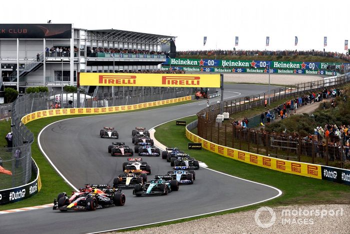 Sergio Pérez, Red Bull Racing RB19, Charles Leclerc, Ferrari SF-23, Lance Stroll, Aston Martin AMR23, Oscar Piastri, McLaren MCL60, el resto de la parrilla en la primera vuelta.