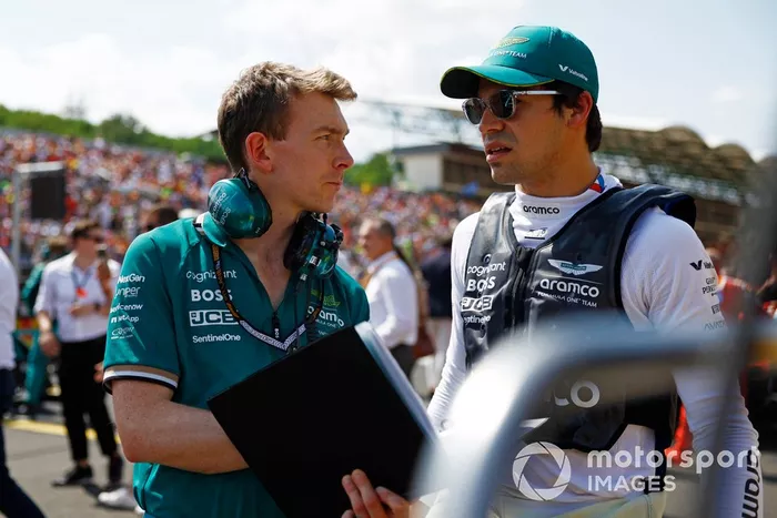 Lance Stroll, del equipo Aston Martin F1, habla con un ingeniero en la parrilla de salida