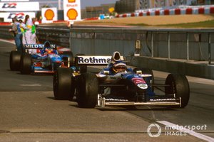 Jacques Villeneuve, Williams FW19 Renault arrives at parc ferme, Jean Alesi, Benetton B197 Renault behind