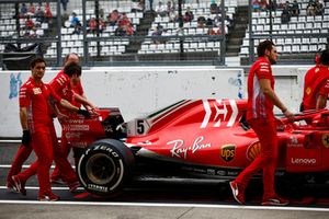 Gli ingegneri Ferrarispostano la monoposto di Sebastian Vettel, Ferrari SF71H, in pit lane