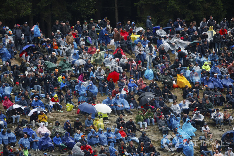 Spectators wear rain gear