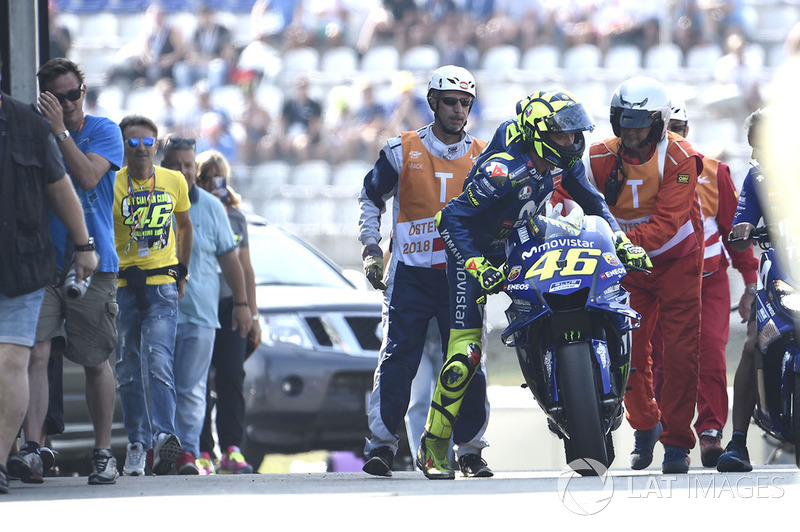 Valentino Rossi, Yamaha Factory Racing, didorong kembali ke garasi setelah kerusakan motor