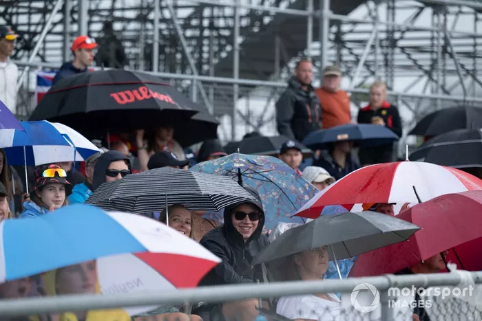 Aficionados bajo paraguas en una tribuna