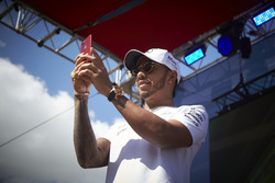 Lewis Hamilton, Mercedes AMG F1, takes a photo of the crowd