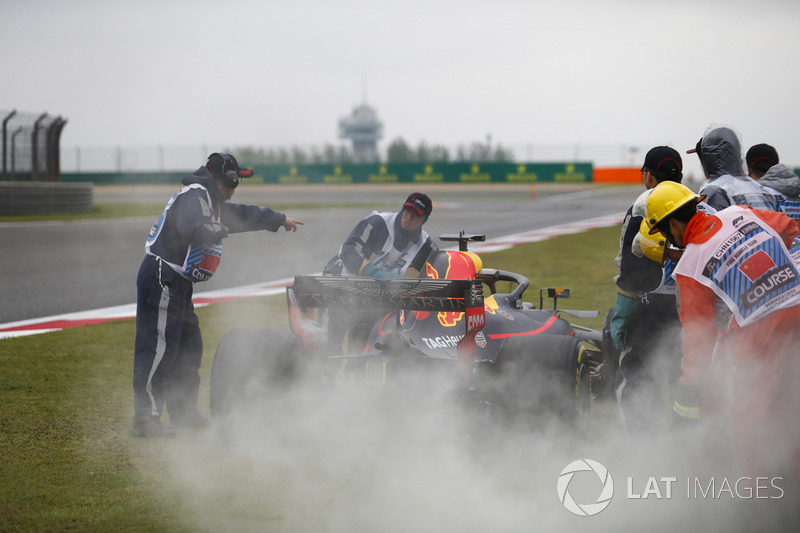 Des commissaires prennent en charge la voiture de Daniel Ricciardo Red Bull Racing RB14 Tag Heuer, après sa défaillance moteur