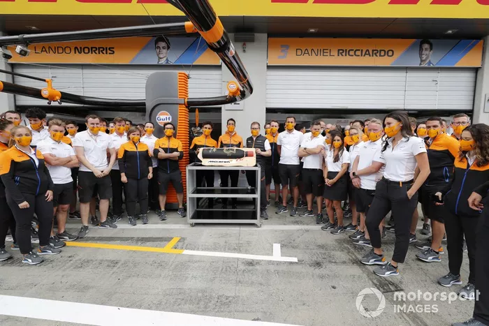 Lando Norris y miembros del equipo McLaren, con una tarta de cumpleaños de Daniel Ricciardo