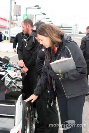 Cara Adams, chief engineer for Firestone Racing, inspects a tire on Josef Newgarden, Team Penske Chevrolet's car