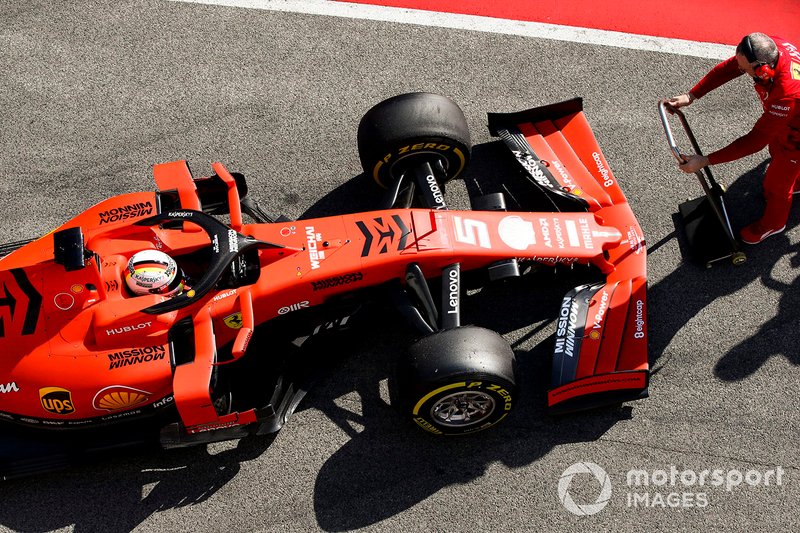Sebastian Vettel, Ferrari SF90, is attended to by a mechanic in the pit lane