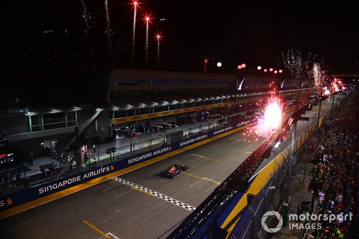 Los fuegos artificiales iluminan el cielo mientras Sergio Pérez, el RB18 de Red Bull Racing, en primera posición, consigue la victoria