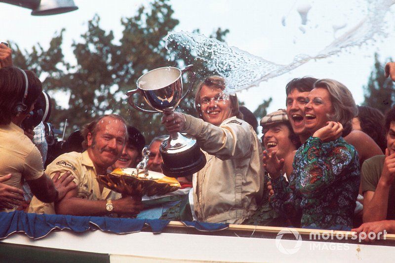 El ganador de la carrera, Ronnie Peterson, del equipo Lotus, celebra en el podio con el jefe del equipo, Colin Chapman. 