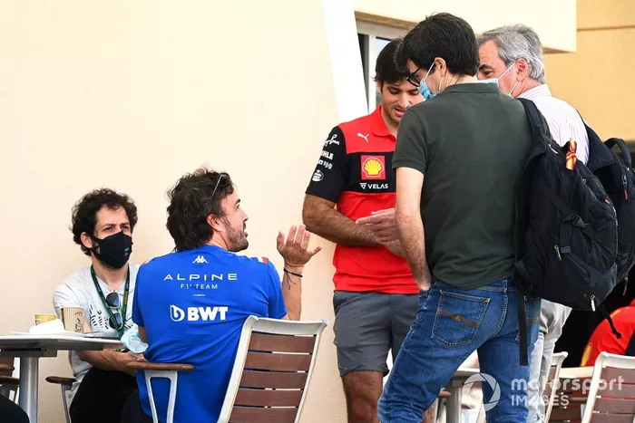 Fernando Alonso, Alpine F1 Team, chats with Carlos Sainz Jr., Ferrari  