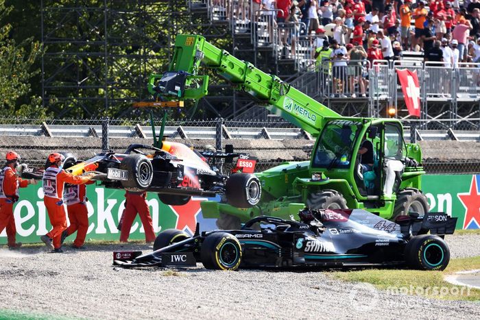 Los oficiales de pista retiran de la grava los coches de Max Verstappen, Red Bull Racing RB16B, y Lewis Hamilton, Mercedes W12