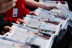 Fans present programmes to be signed by drivers