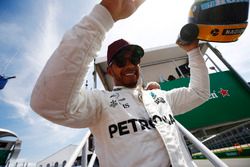 Lewis Hamilton, Mercedes AMG F1, shows off his Ayrton Senna helmet, a gift after equalling the Brazilian's pole record, to fans.
