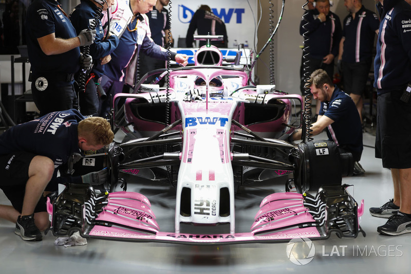 Les commissaires travaillent sur la voiture de Sergio Perez, Force India VJM11, dans le garage