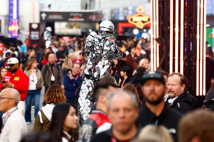  A stilted performer in a mirror suit performs in the Paddock Club