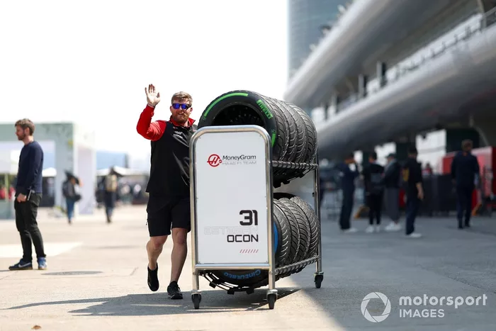 A Haas F1 team member in the Pitlane with a tyre cart 