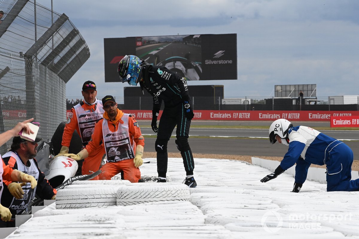 George Russell, Mercedes-AMG, assists marshals in extracting Zhou Guanyu, Alfa Romeo F1 Team, from his car