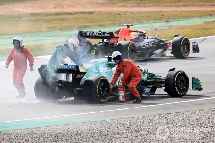 Oficiales de pista asisten a Sebastian Vettel, Aston Martin AMR22, después de que un fallo técnico produzca humo