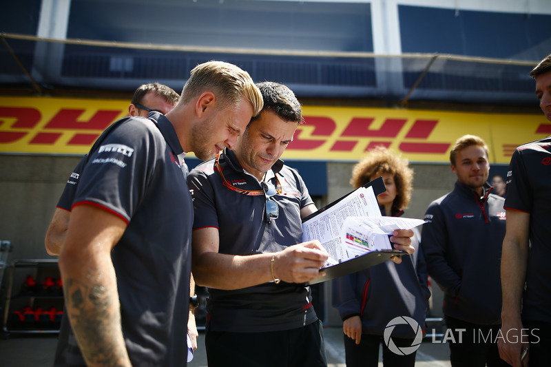 Kevin Magnussen, Haas F1 Team, views a document with engineer Guiliano Salvi