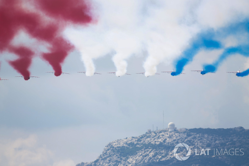 The French Air Force Aerobatics team, La Patrouille de France, overfly the grid in their Dassault Alpha Jet Es