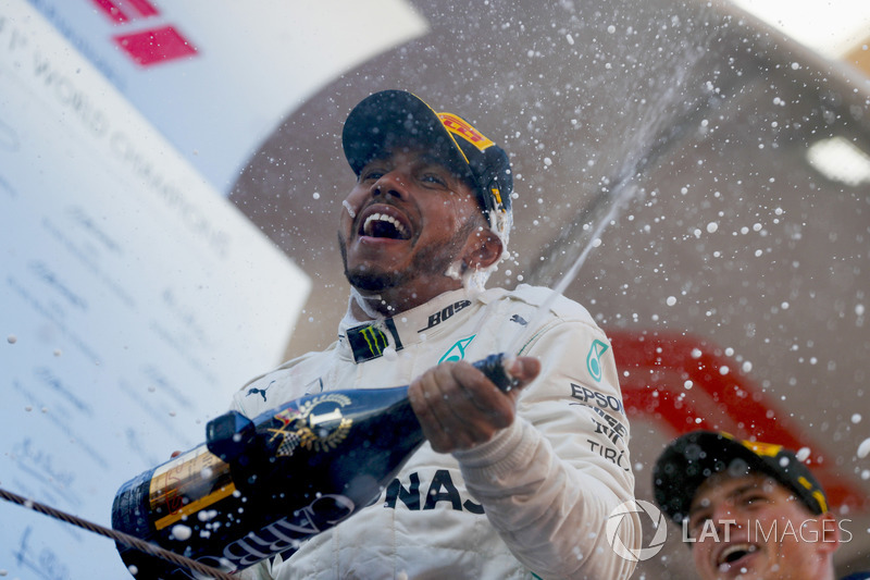 Lewis Hamilton, Mercedes AMG F1 W09, celebrates victory by spraying champagne with Max Verstappen, Red Bull Racing, on the podium