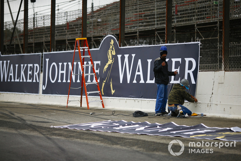 Workmen apply the final touches to a Johnnie Walker advertising sign