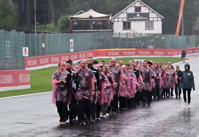 Personal de pista con ponchos para la lluvia 