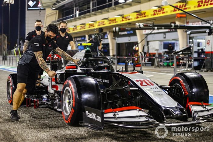 Los mecánicos de Haas F1 empujan el Haas VF-20 de Kevin Magnussen por el pitlane