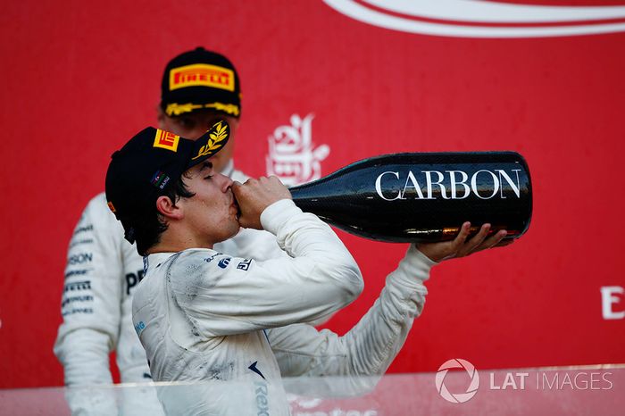 Lance Stroll, Williams, bebe champán en el podio por delante de Valtteri Bottas, Mercedes AMG F1