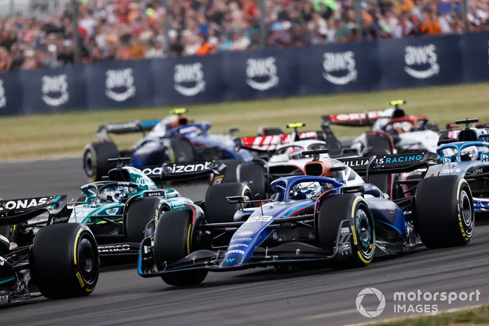 Alex Albon, Williams FW45, Lance Stroll, Aston Martin AMR23, Esteban Ocon, Alpine A523, el resto de la parrilla en la primera vuelta.