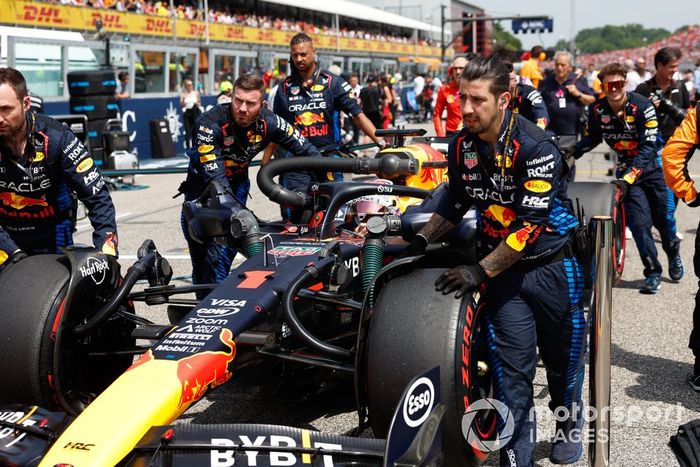 Los mecánicos de Red Bull Racing empujan el coche de Max Verstappen, el Red Bull Racing RB20 a su hueco en parrilla