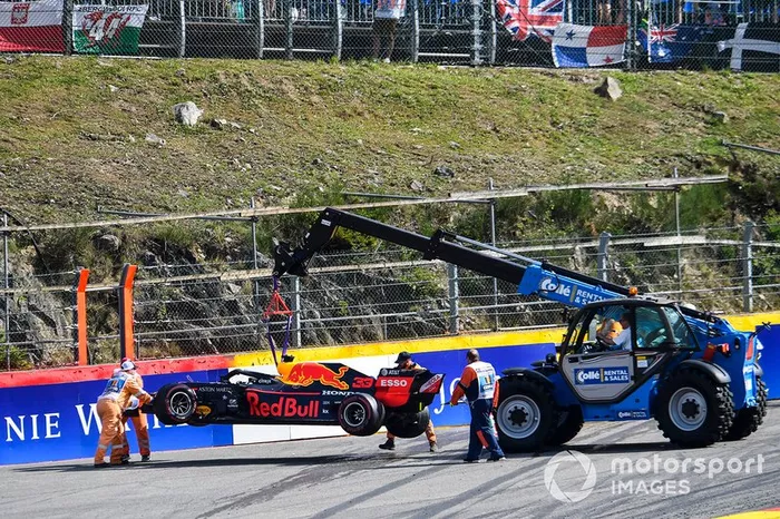 El coche de Max Verstappen Red Bull Racing RB15 dañado es retirado por una grúa y los oficiales