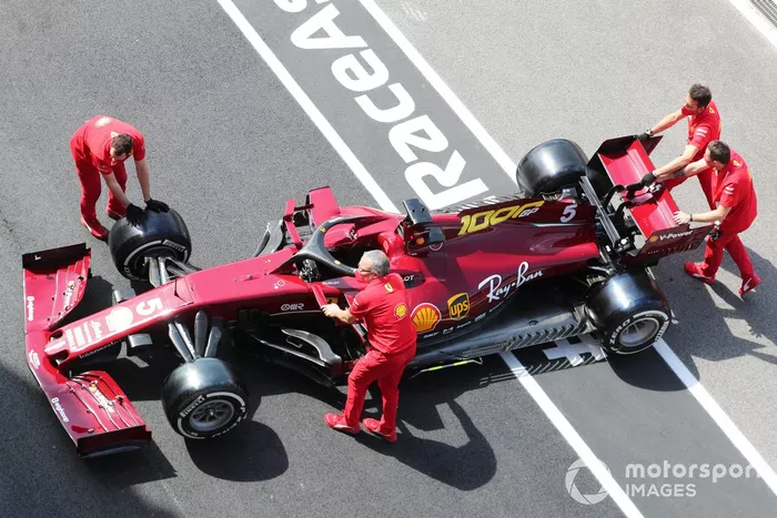 Miembros de Ferrari con el coche de Sebastian Vettel