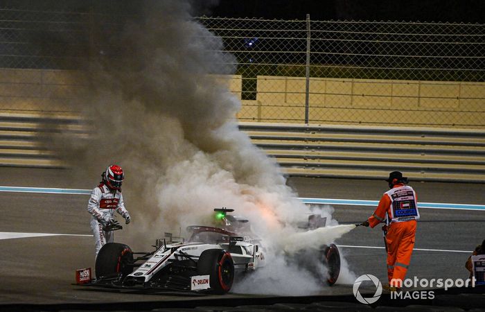 Un oficial de pista extingue las llamas del monoplaza de Kimi Raikkonen, Alfa Romeo Racing C39