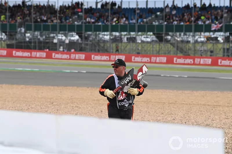 A marshal pick up debris after the opening lap crash