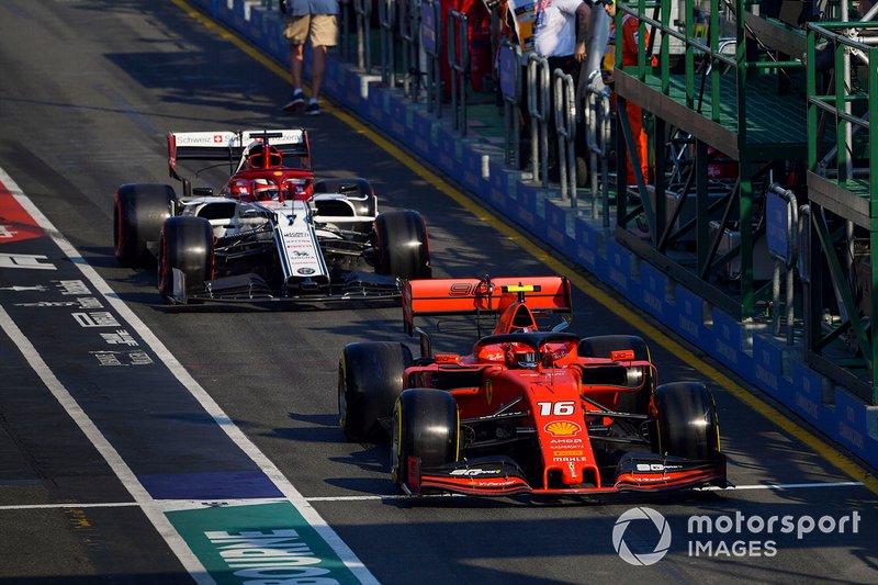 Charles Leclerc, Ferrari SF90, leads Kimi Raikkonen, Alfa Romeo Racing C38, in the pit lane