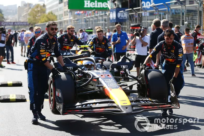 Les mécaniciens amènent Sergio Perez, Red Bull Racing RB20, sur la grille de départ.