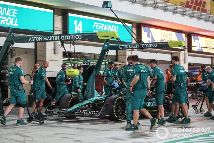 Los mecánicos empujan a Lance Stroll, Aston Martin AMR24, de vuelta al garaje 