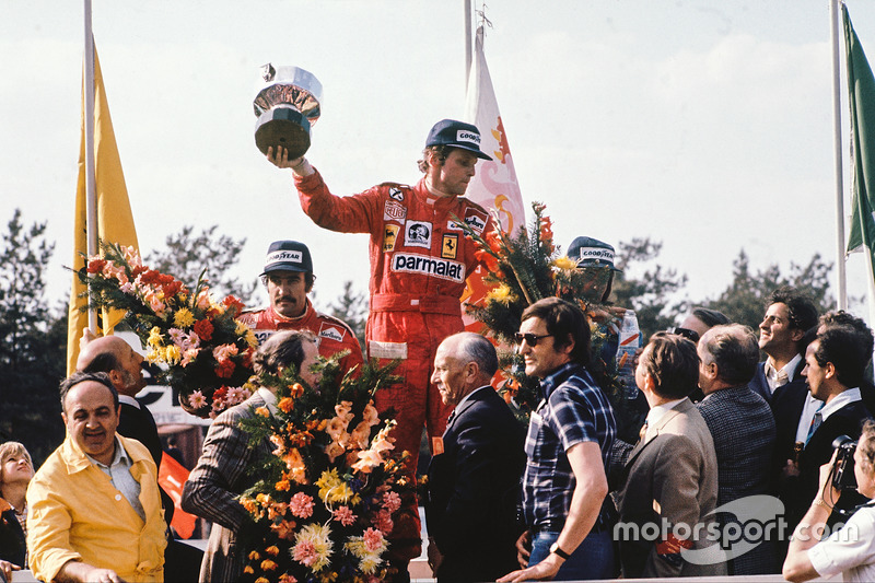 Race winner Niki Lauda, Ferrari, celebrates with second place Clay Regazzoni, Ferrari and third plac