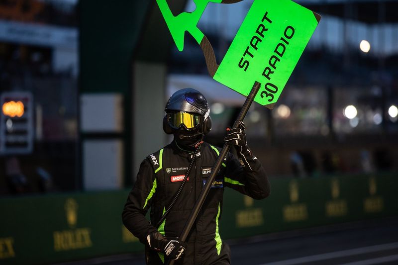 Miembro del #30 Duqueine Team Oreca 07 - Gibson LMP2, en pits con un letrero