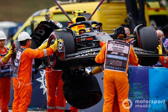 Los comisarios retiran el coche dañado de Sergio Pérez, Red Bull Racing RB20