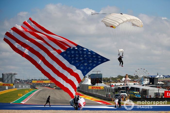 Un paracaidista llega con una bandera estadounidense