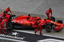 Des mécaniciens avec la Ferrari SF71H dans la voie des stands