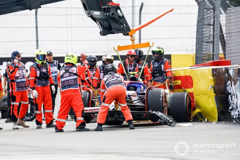 Les commissaires retirent la voiture endommagée de Yuki Tsunoda, RB F1 Team VCARB 01, d'une barrière après un accident à la fin de la Q2.