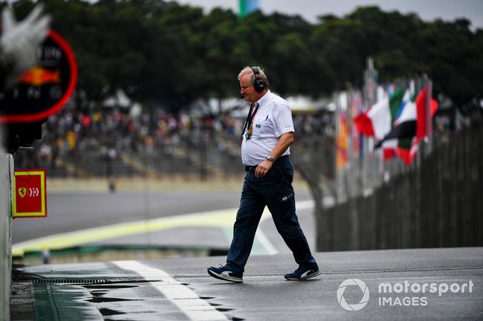 Un miembro de la FIA camina a través del pit lane