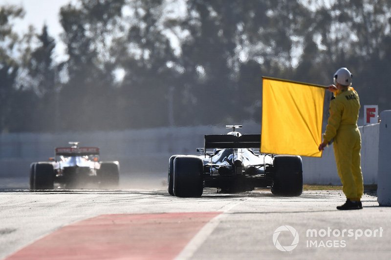 Comisarios con la bandera amarilla en el pitlane