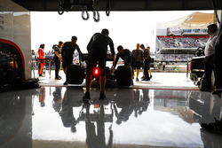McLaren engineers return Fernando Alonso, McLaren MCL32, to the garage