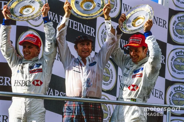 Race winner Johnny Herbert, Jackie Stewart, Team Principal, Stewart Grand Prix, and Rubens Barrichello, 3rd place, celebrate on the podium
