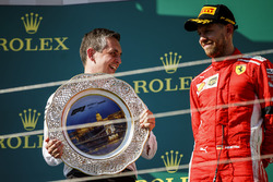 Mercedes AMG F1 team member celebrates on podium and Sebastian Vettel, Ferrari